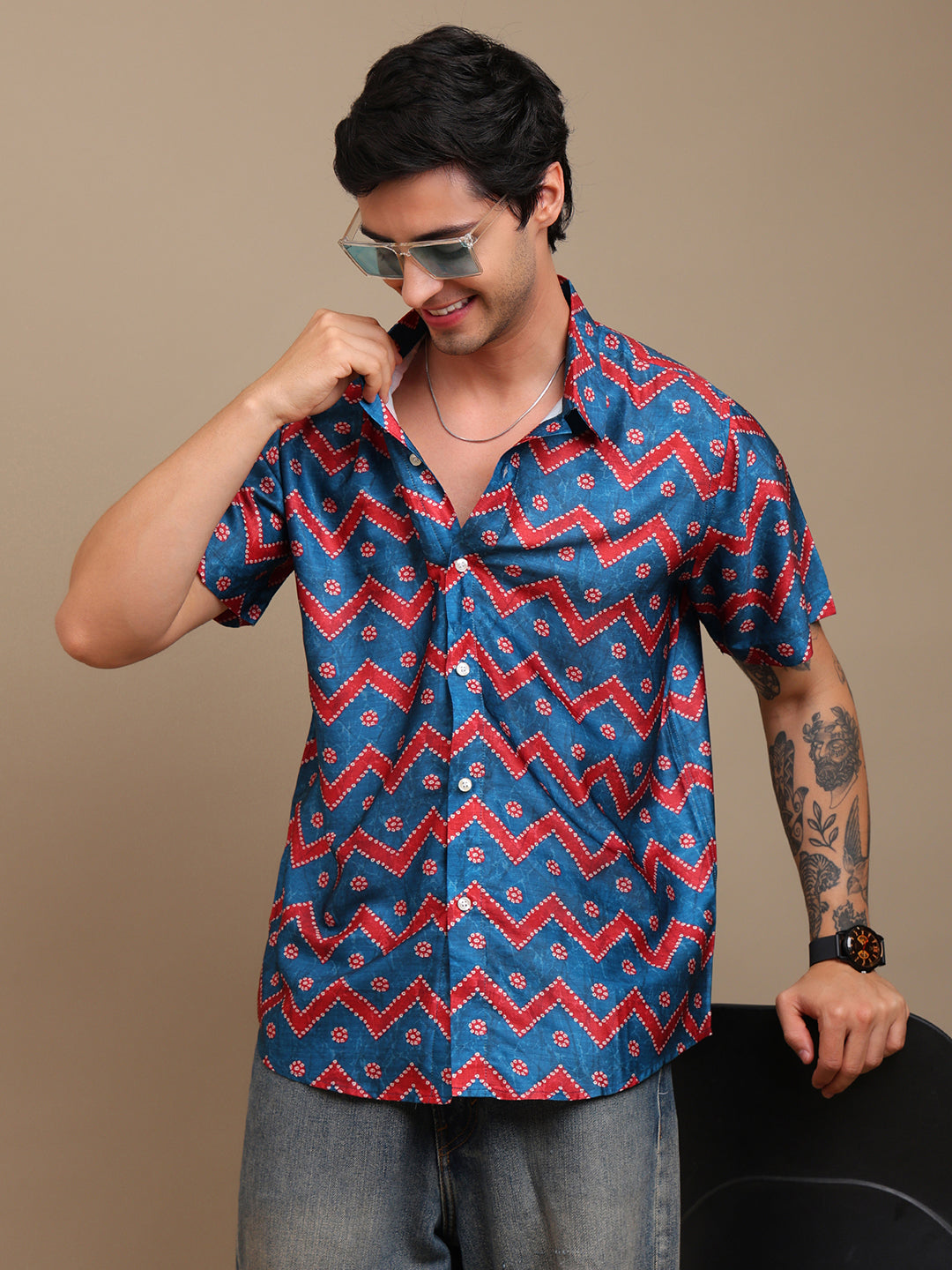 Man wearing a blue and red patterned shirt against a beige background