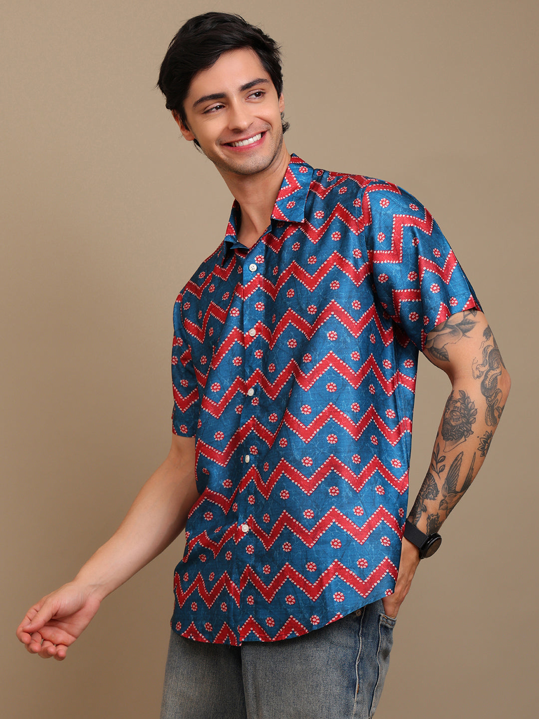 Man wearing a blue and red patterned shirt against a beige background