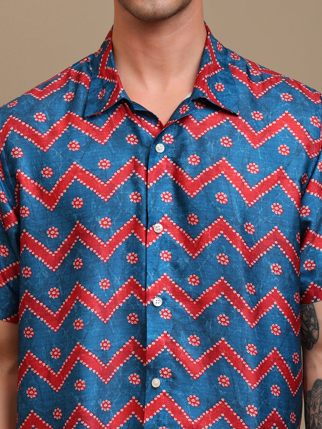 Man wearing a blue and red patterned shirt with a zigzag design.