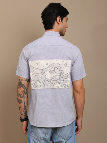 Man wearing a Grey shirt with a unique design on the back against a beige background