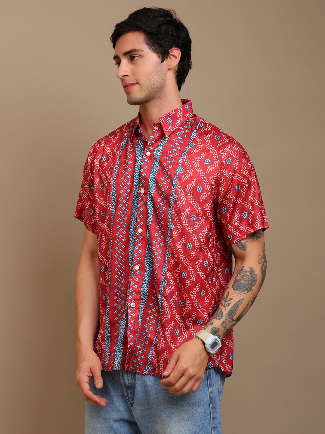 Man wearing a red patterned shirt against a brown background