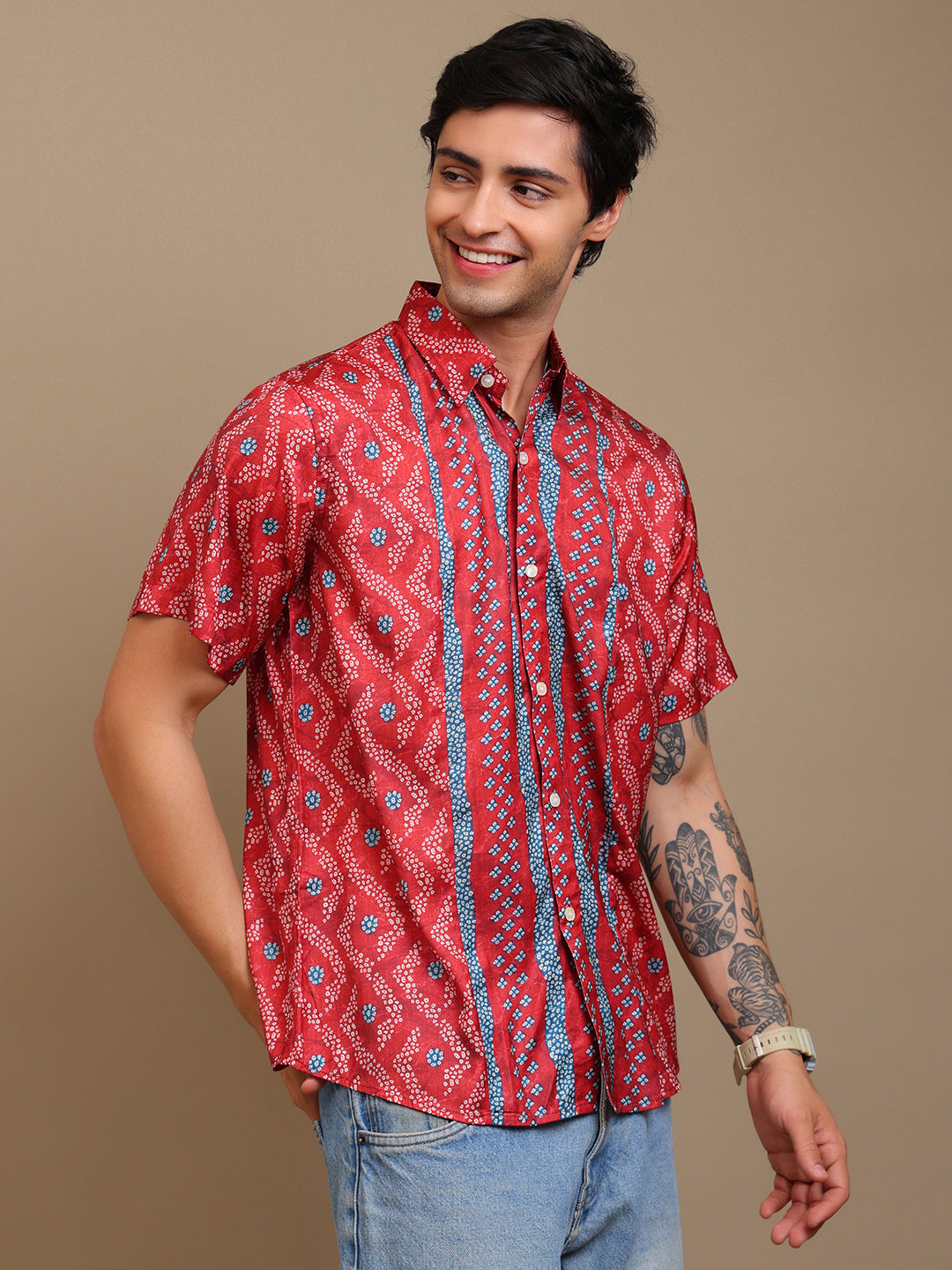 Man wearing a red patterned shirt against a beige background