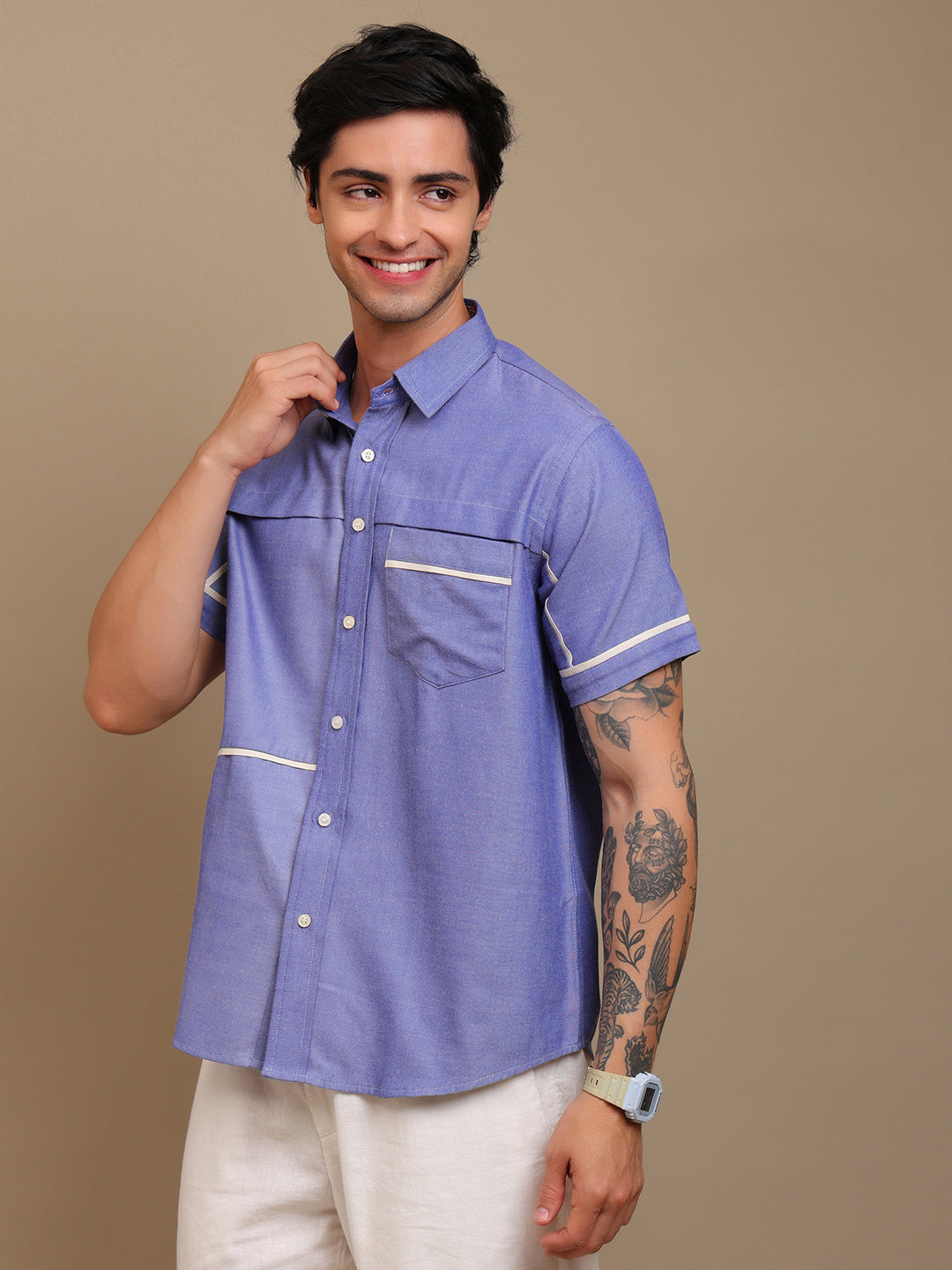 A man wearing blue shirt and a white watch with white pants