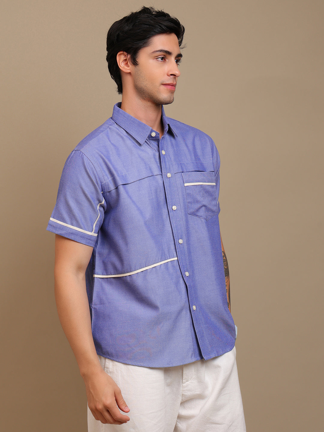 A man wearing blue shirt and white pants