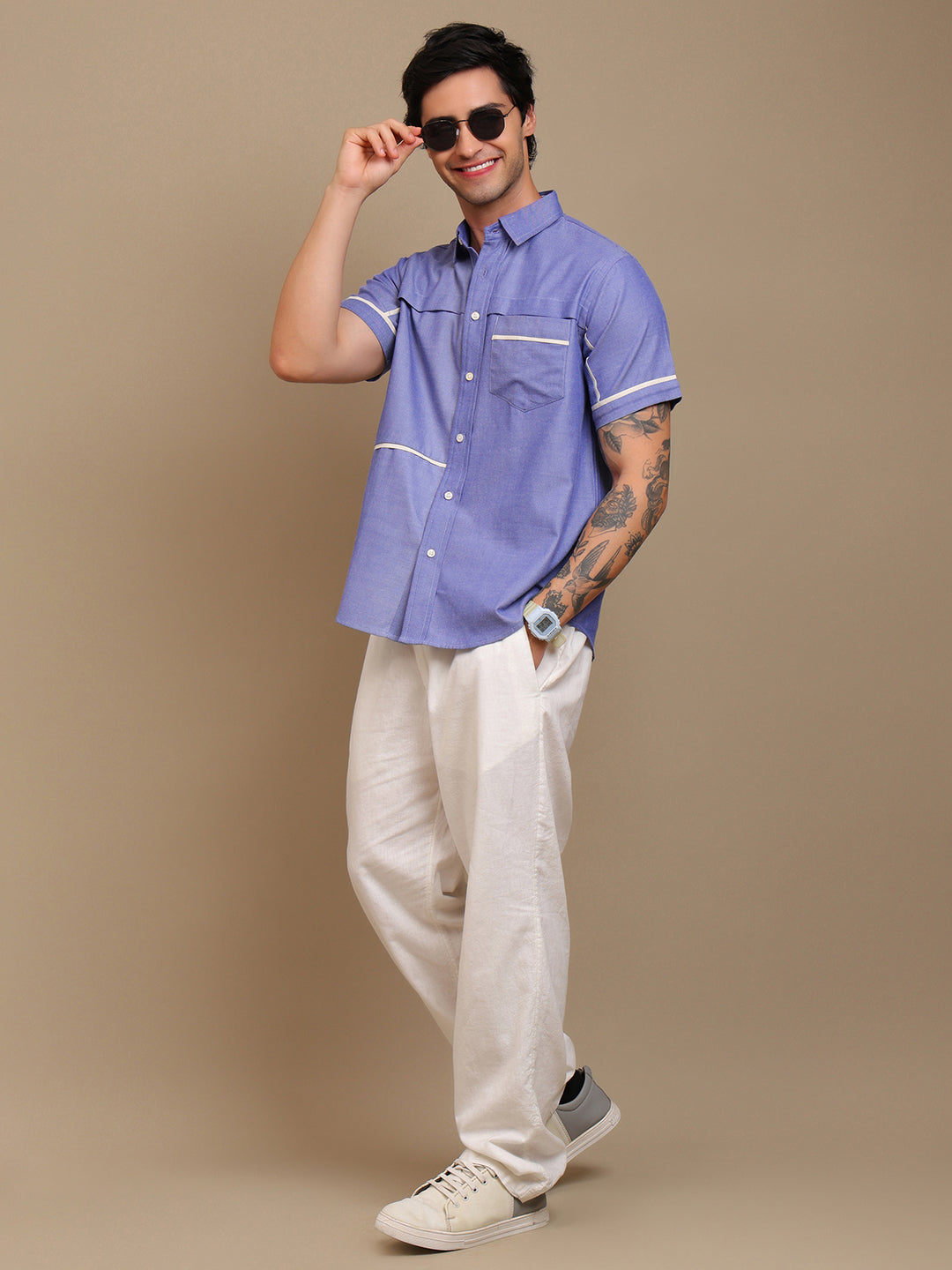 A man wearing blue shirt with sunglass and smiling