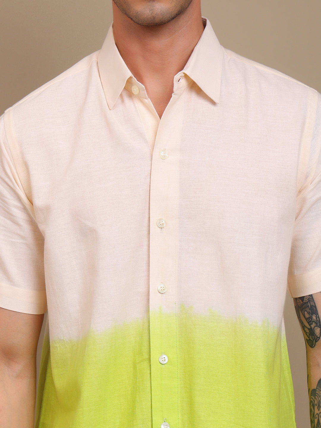 Man wearing a shirt with a gradient design from beige to green.