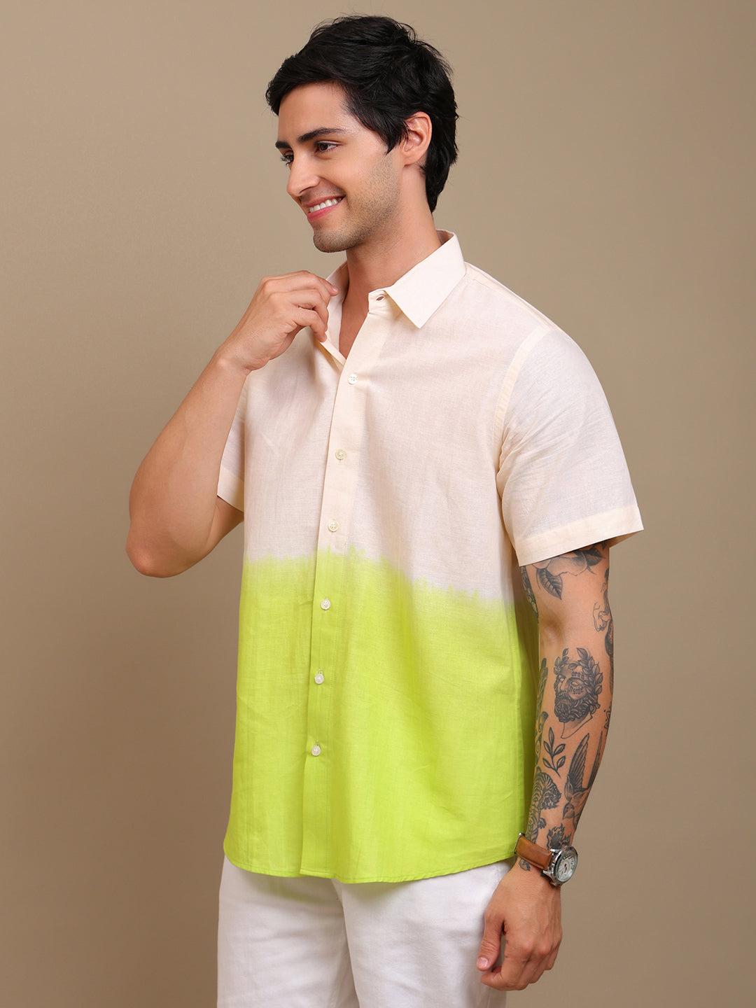 Man wearing a two-tone shirt with a beige top and green bottom against a brown background