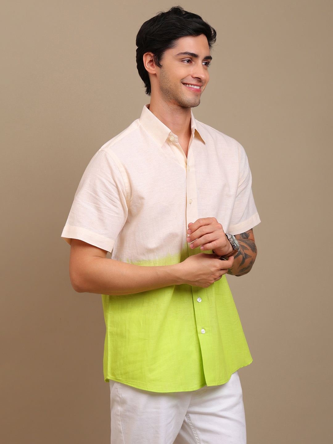 Man wearing a two-tone shirt with a beige and green design on a brown background